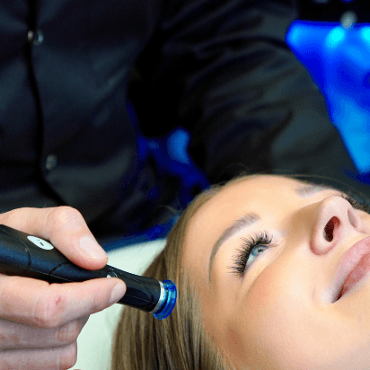 Dermatolog MUDr. Martin Bortlík ošetřuje pleť pacientky v oblasti tváří pomocí přístroje HydraFacial.