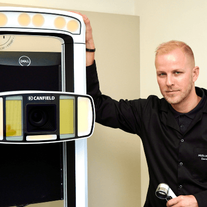MUDr. Martin Bortlík, dermatolog ze Skinity Clinic, stojí vedle přístroje IntelliStudio by Canfield používaného pro analýzu a kontrolu znamének.