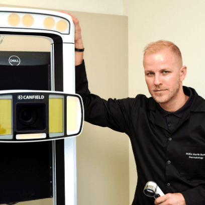MUDr. Martin Bortlík, dermatolog ze Skinity Clinic, stojí vedle přístroje IntelliStudio by Canfield používaného pro analýzu a kontrolu znamének.
